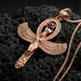 Load image into Gallery viewer, Sterling silver winged Isis pendant with a rose gold plated finish, Egyptian goddess amulet with outstretched wings and oval halo design, macro on black volcanic rock
