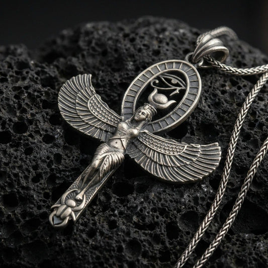 Sterling silver Egyptian Isis winged pendant with an oxidized finish, goddess figure with spread wings and oval hieroglyph halo, close-up on black volcanic rock