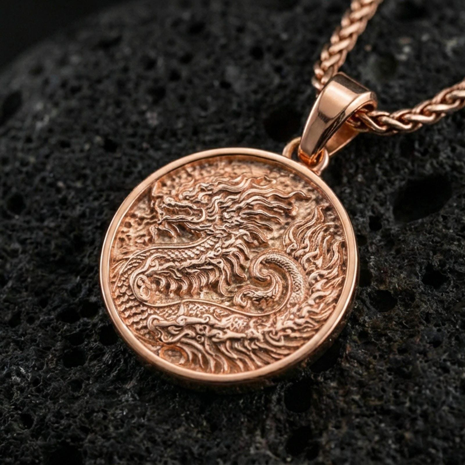 Rose gold plated round dragon coin pendant necklace on textured volcanic rock, centered studio-style close-up showcasing soft rosy glow and intricate dragon engraving.
