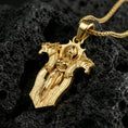 Load image into Gallery viewer, Gold plated gothic cross pendant necklace on textured volcanic rock, premium close-up showcasing warm reflective shine across the angelic knight design and raised contours.
