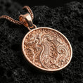 Load image into Gallery viewer, Rose gold plated dragon medallion pendant necklace on textured volcanic rock, centered studio-style close-up showcasing soft rosy glow and intricate dragon relief detail.
