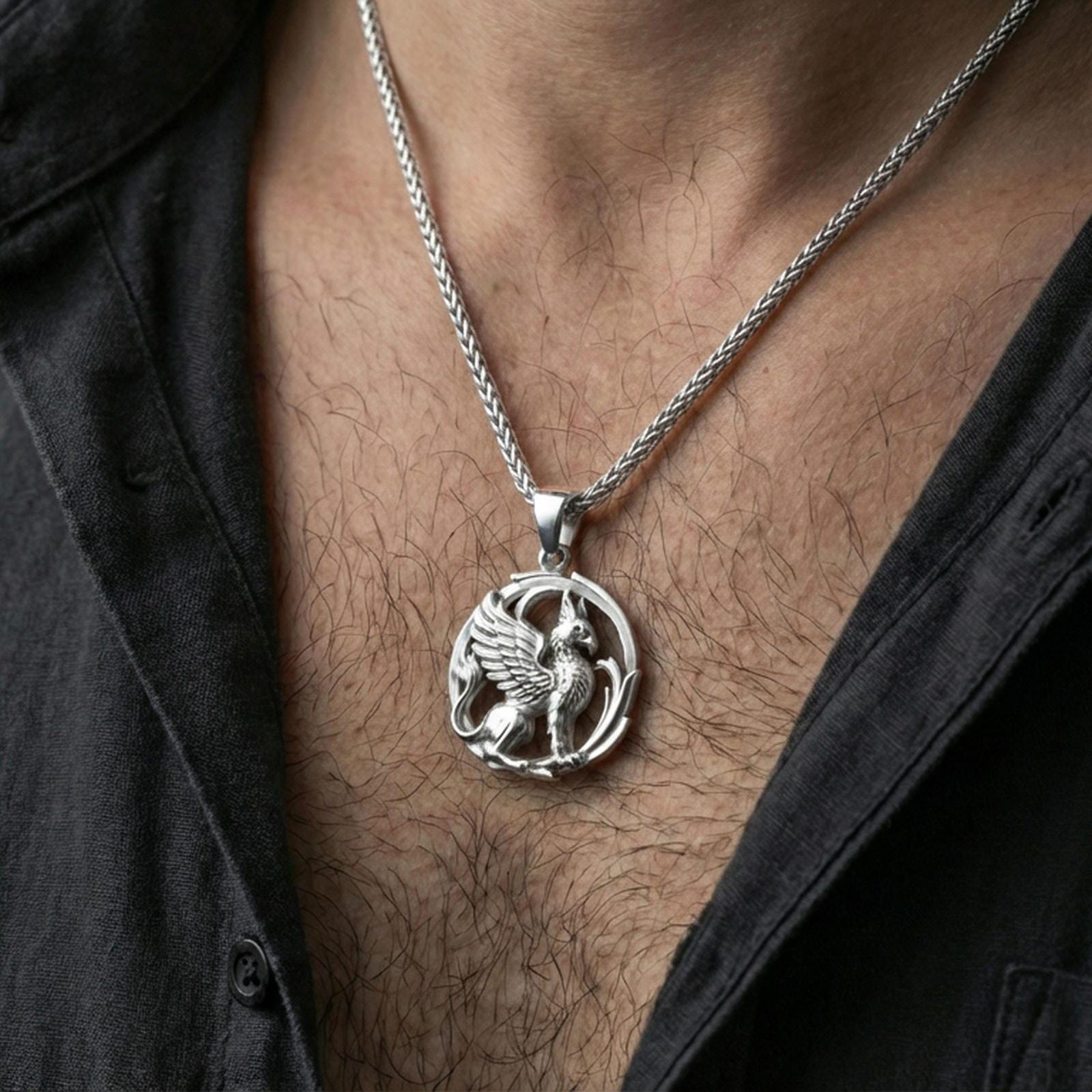 Polished silver griffin pendant necklace worn on the neck, clean lifestyle wear shot capturing bright shine and the detailed fantasy creature relief in natural light.
