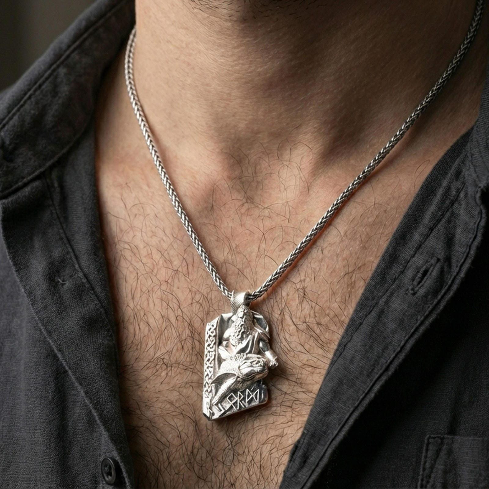 Polished silver Njord Norse sea god pendant necklace worn on the neck, clean lifestyle wear shot capturing bright shine and the detailed Norse figure-and-rune relief in natural light.