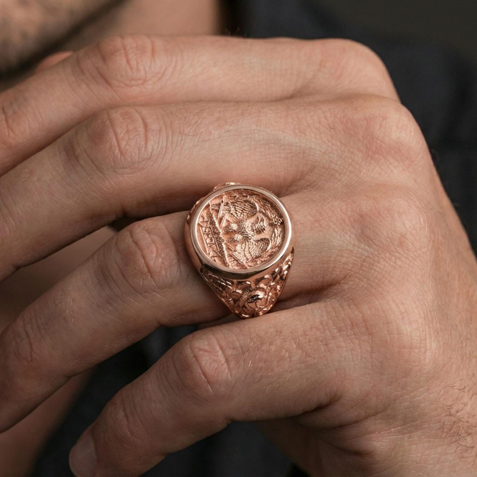 Rose gold plated SPQR ring worn on a finger, close-up showing the engraved roman insignia and raised borders