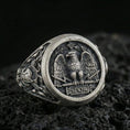 Load image into Gallery viewer, Close-up of an oxidized sterling silver SPQR roman eagle signet ring on porous volcanic rock in a dark studio
