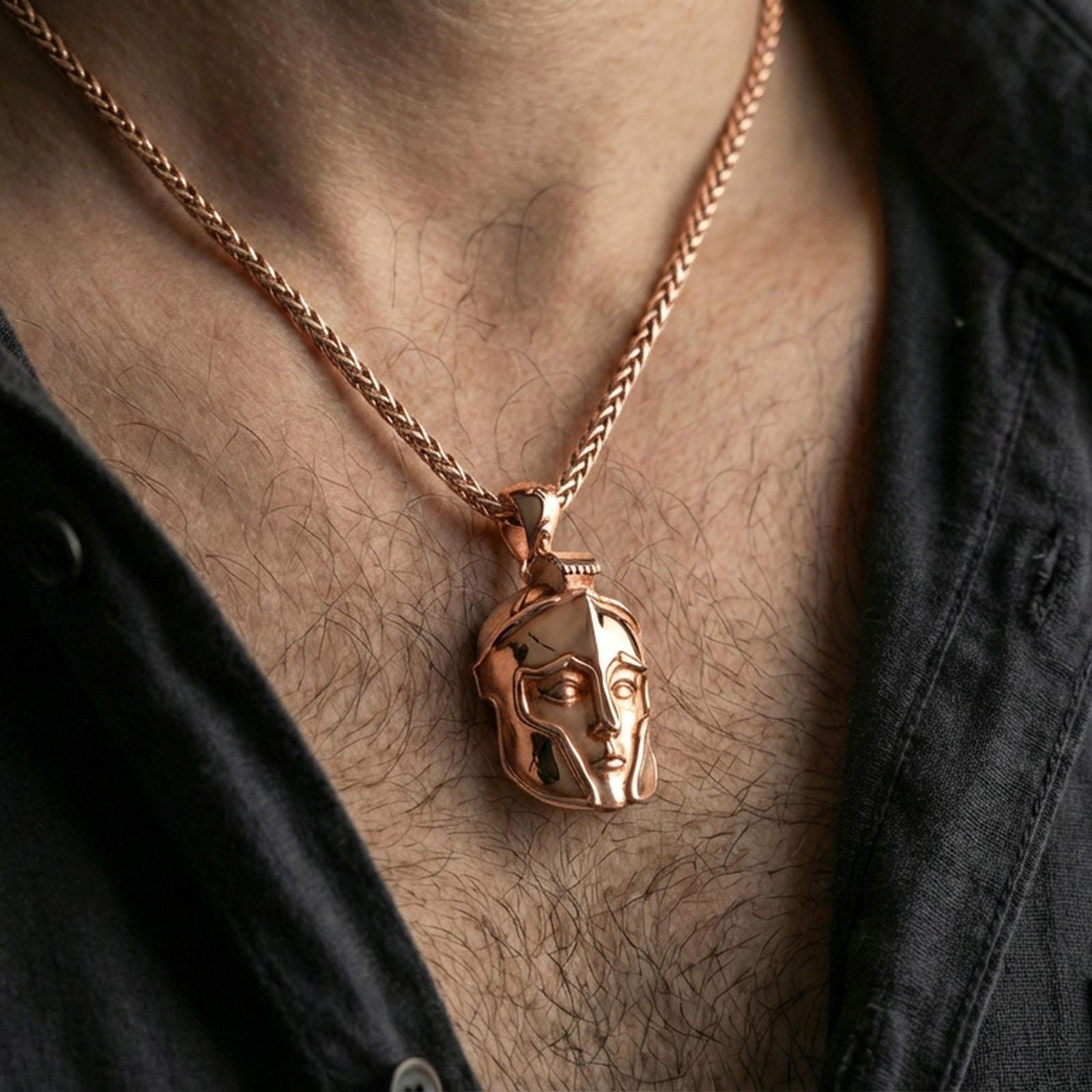 Rose gold plated Spartan helmet pendant necklace on neck, close-up lifestyle image showcasing the helmet relief, smooth edges, and warm finish