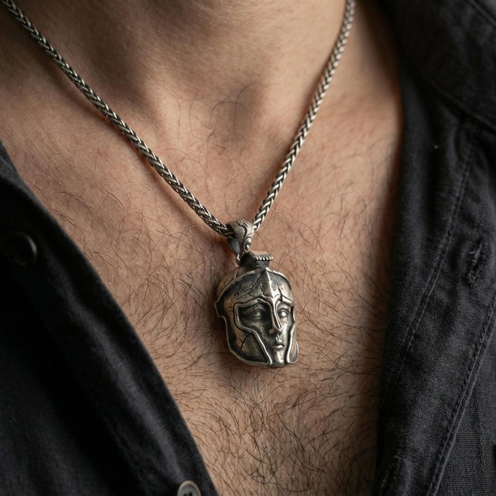 Oxidized Greek helmet pendant necklace worn on neck, lifestyle close-up showing the warrior faceplate motif and rugged antique character