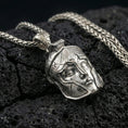 Load image into Gallery viewer, Polished silver Spartan helmet pendant on porous volcanic stone, close-up focusing on the sculpted facial features, sharp contours, and clean reflective edges
