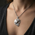 Load image into Gallery viewer, Polished silver Athena warrior pendant necklace worn on the neck, clean lifestyle wear shot capturing bright shine and the detailed spear-and-shield relief in natural light.
