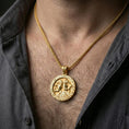 Load image into Gallery viewer, Gold plated Horus and Anubis pendant necklace worn on the neck, lifestyle photo featuring warm tone finish and strong statement medallion presence.
