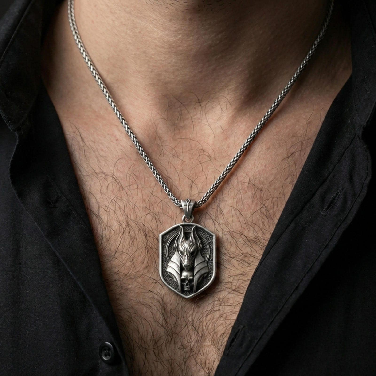 Oxidized Anubis pendant necklace worn on the neck, lifestyle framing showing realistic scale and bold vintage contrast against the chest.