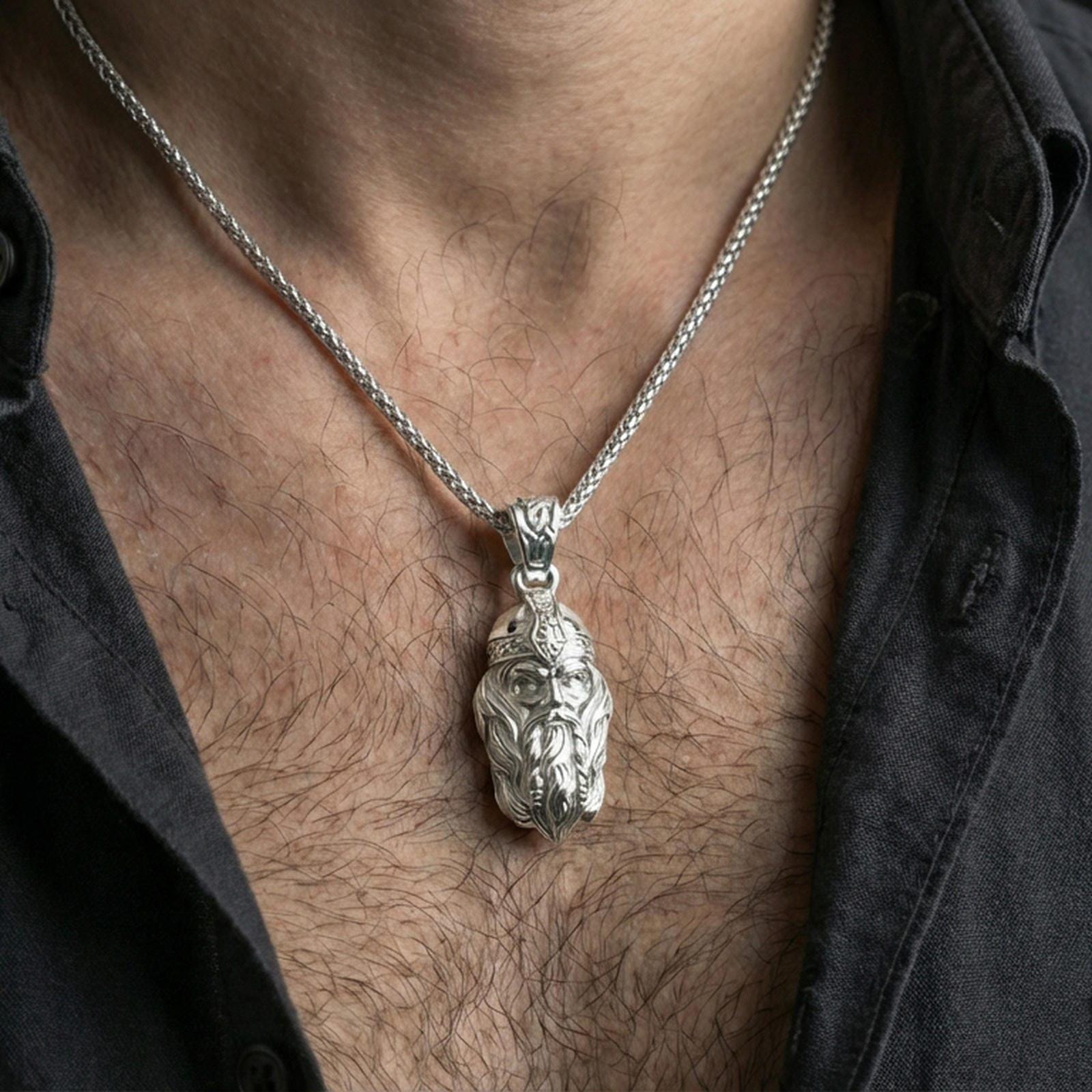 Polished silver Viking warrior head pendant necklace worn on the neck, clean lifestyle wear shot capturing bright shine and the detailed warrior portrait relief in natural light.