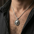 Load image into Gallery viewer, Polished silver demon mask medallion pendant necklace worn on the neck, clean lifestyle wear shot capturing bright shine and the detailed horn-and-fang relief in natural light.
