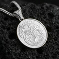 Load image into Gallery viewer, Polished silver Urnes style Viking beast pendant necklace on textured volcanic rock, crisp macro product photo emphasizing clean edges, sharp scrollwork lines, and bright reflective highlights on the engraved design.
