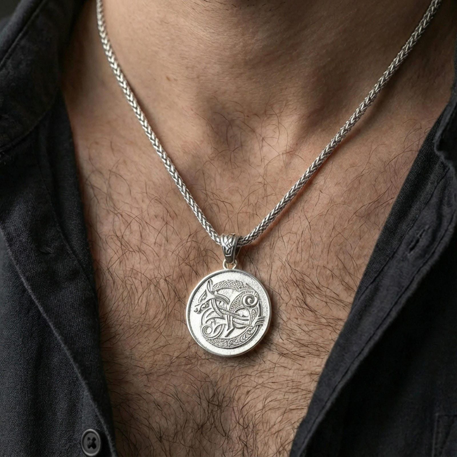 Polished silver Urnes style Viking beast pendant necklace worn on the neck, clean lifestyle wear shot capturing bright shine and the detailed Nordic interlace motif in natural light.