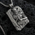 Load image into Gallery viewer, Oxidized Thor pendant necklace on textured volcanic rock, centered close-up highlighting the Norse god relief, Mjölnir hammer detail, rune lettering, and deep antique shadowed contrast.

