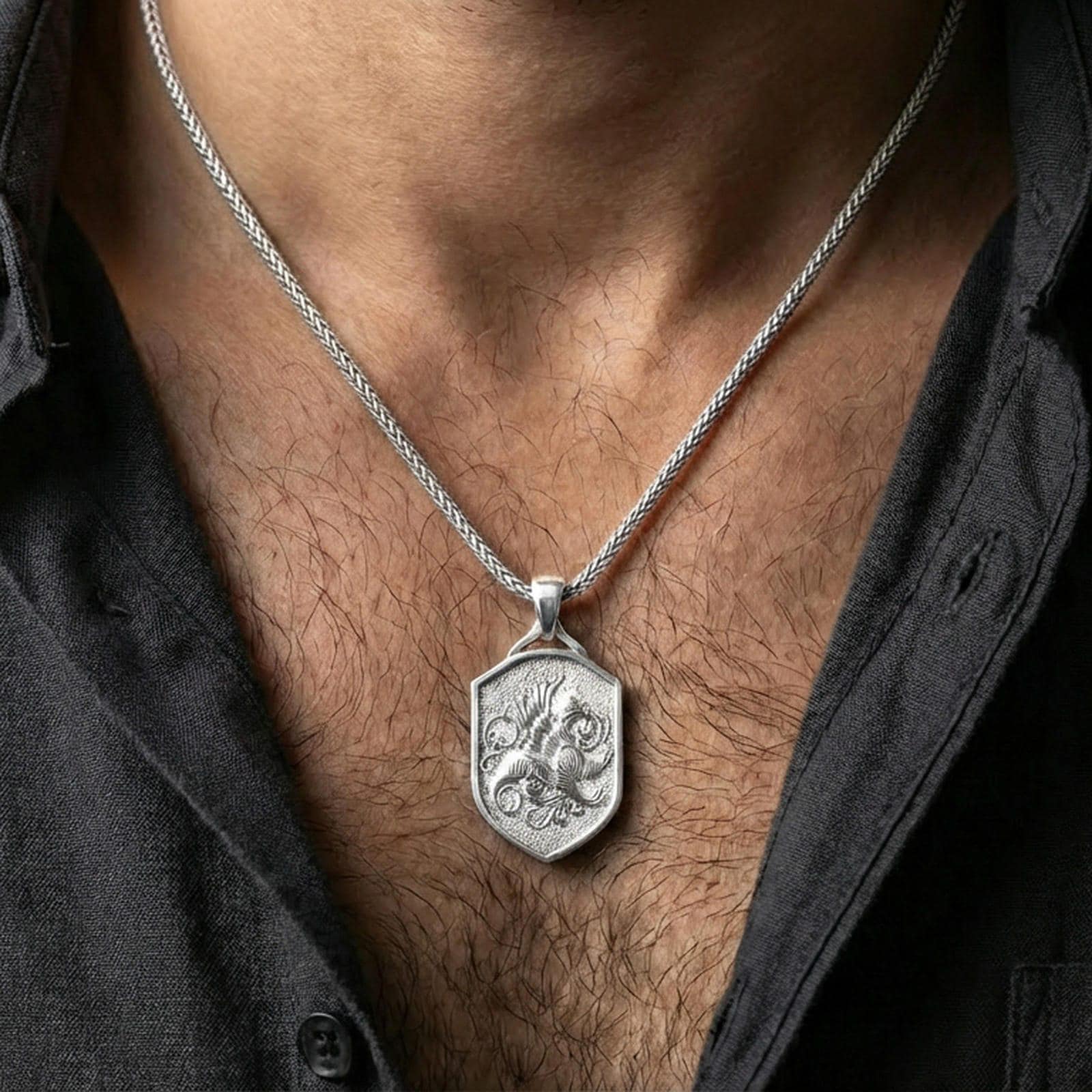 Polished silver griffin shield pendant necklace worn on the neck, clean lifestyle wear shot capturing bright shine and the detailed gryphon relief in natural light.
