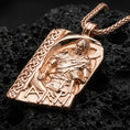 Load image into Gallery viewer, Rose gold plated Norse moon god pendant necklace on textured volcanic rock, centered studio-style close-up showcasing soft rosy glow and intricate Viking relief detailing with clear rune lettering.
