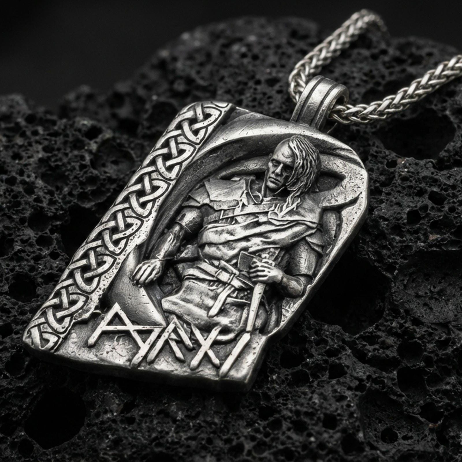 Oxidized Norse moon god pendant necklace on textured volcanic rock, centered close-up highlighting the seated deity relief, Celtic knot border, rune lettering, and deep antique shadowed contrast.