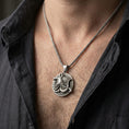 Load image into Gallery viewer, Oxidized Anubis medallion pendant necklace worn on the neck, lifestyle framing showing realistic scale and bold vintage contrast against the chest.
