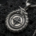 Load image into Gallery viewer, Oxidized sterling silver dragon compass pendant on porous volcanic rock, close-up showing the compass rose centerpiece
