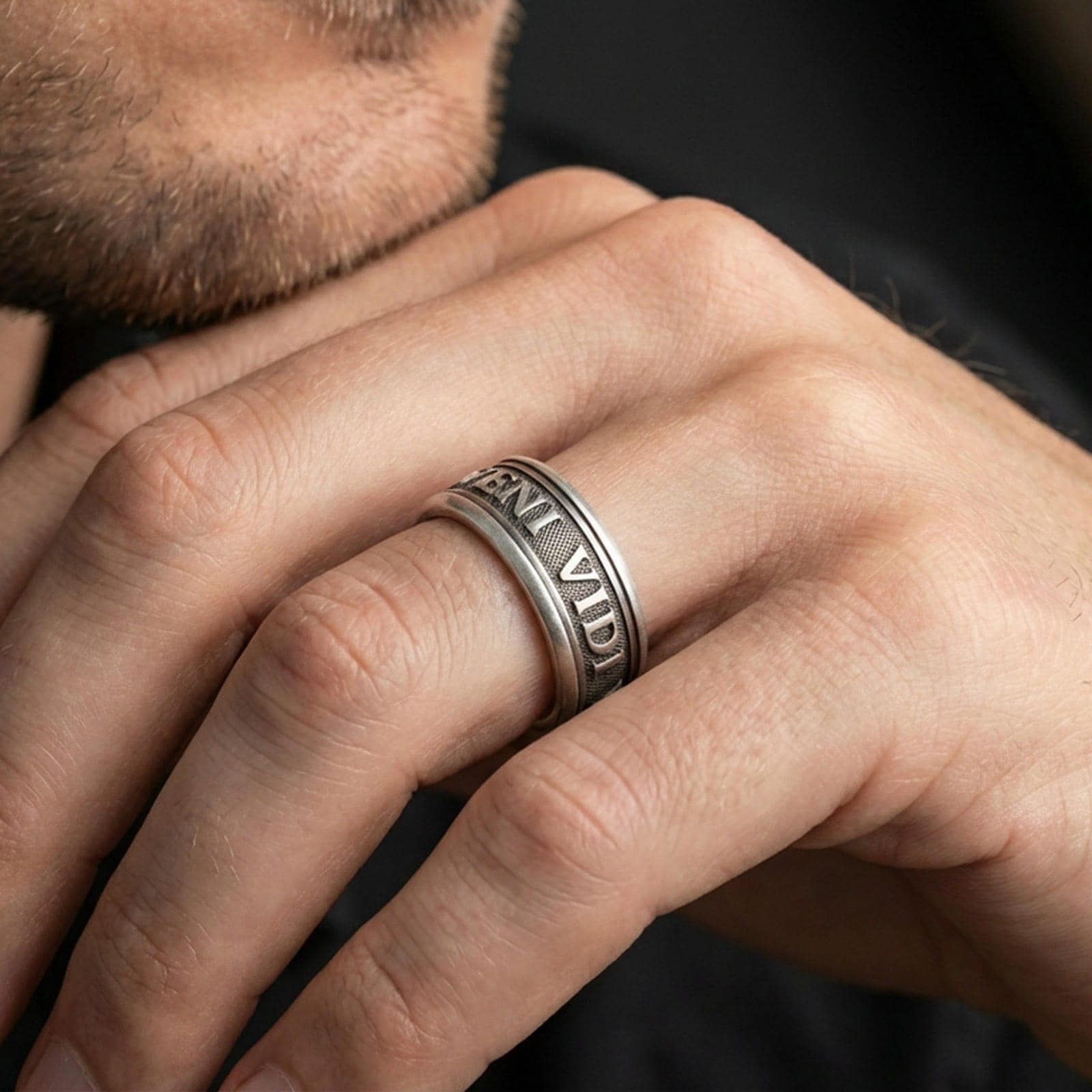 Oxidized Veni Vidi Vici spinner ring worn on a finger, lifestyle framing showing realistic scale and bold vintage contrast in a natural hand pose.