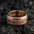 Load image into Gallery viewer, Rose gold plated Veni Vidi Vici spinner ring on textured volcanic rock, centered studio-style close-up showcasing soft rosy glow and crisp Latin quote engraving with a refined finish.
