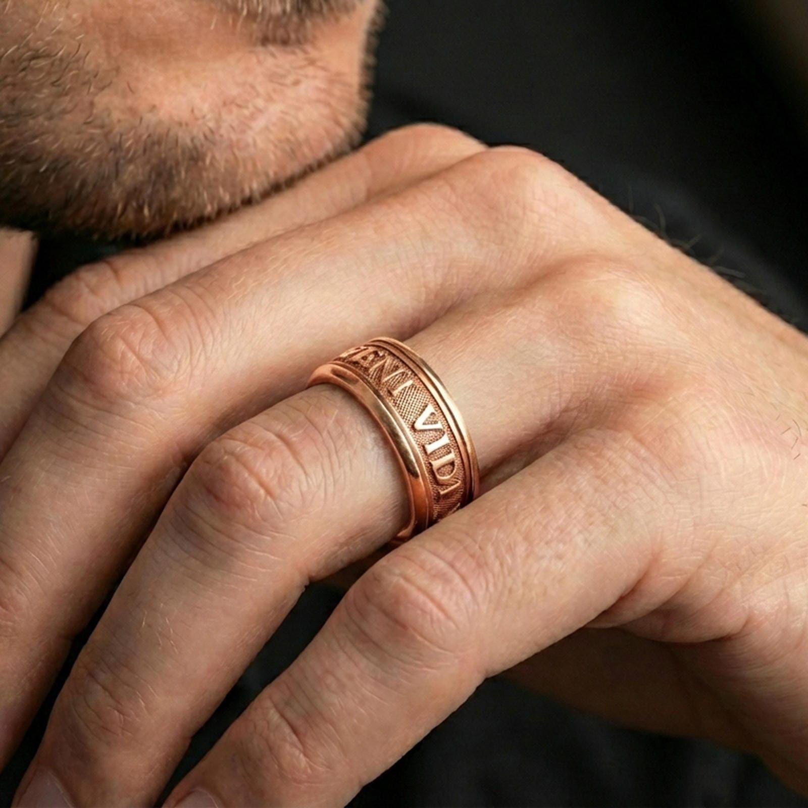 Rose gold plated Veni Vidi Vici spinner ring worn on a finger, lifestyle wear shot with elegant rosy shine and crisp Roman quote detailing visible.