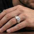 Load image into Gallery viewer, Polished silver wolf head band ring worn on a finger, clean lifestyle wear shot capturing bright shine and the detailed wolf relief in natural light.
