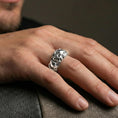 Load image into Gallery viewer, Polished silver skull band ring worn on a finger, clean lifestyle wear shot capturing bright shine and the detailed skull relief in natural light.

