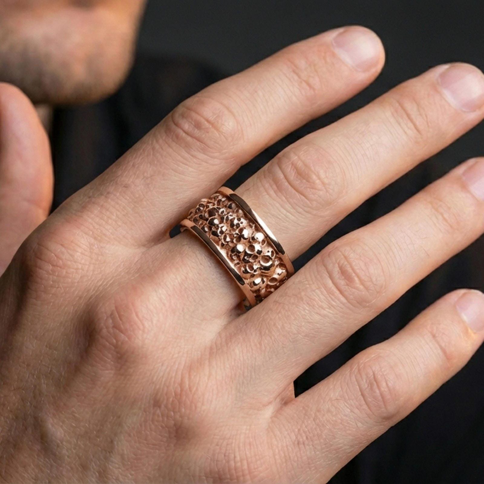 Rose gold plated skull cuff ring worn on a finger, lifestyle wear shot with elegant rosy shine and crisp skull detailing visible.