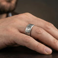 Load image into Gallery viewer, Oxidized Egyptian symbols band ring worn on a finger, lifestyle framing showing realistic scale and bold vintage contrast in a natural hand pose.

