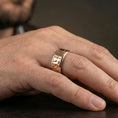 Load image into Gallery viewer, Rose gold plated Egyptian symbols band ring worn on a finger, lifestyle wear shot with elegant rosy shine and crisp Egyptian symbol detailing visible.
