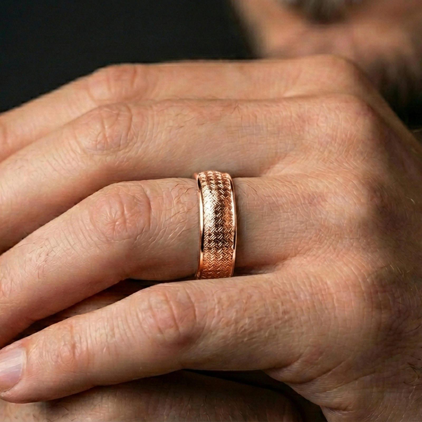 Rose gold plated woven texture band ring worn on a finger, lifestyle wear shot with elegant rosy sheen and sharp focus on the woven texture.