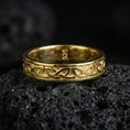 Load image into Gallery viewer, Gold plated Celtic knot band ring on volcanic stone, premium close-up highlighting warm gold tone across the woven pattern and smooth rounded profile.
