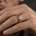 Load image into Gallery viewer, Rose gold plated Celtic knot band ring worn on a finger, lifestyle photo featuring elegant rosy sheen and detailed Celtic knot engraving.

