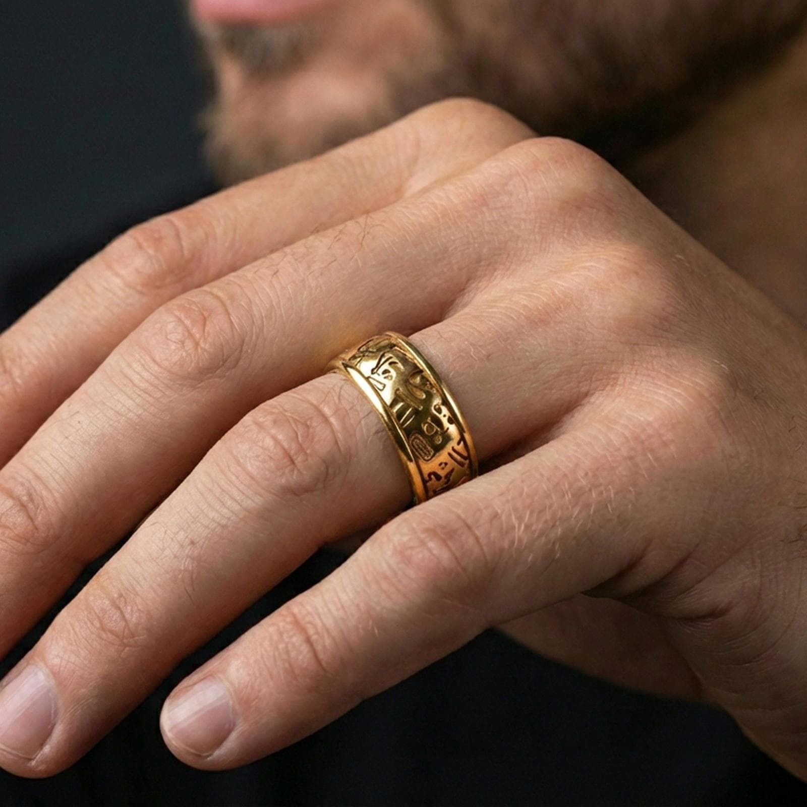 Gold plated hieroglyph band ring worn on a finger, lifestyle image featuring rich gold shine and readable hieroglyph engravings around the band.