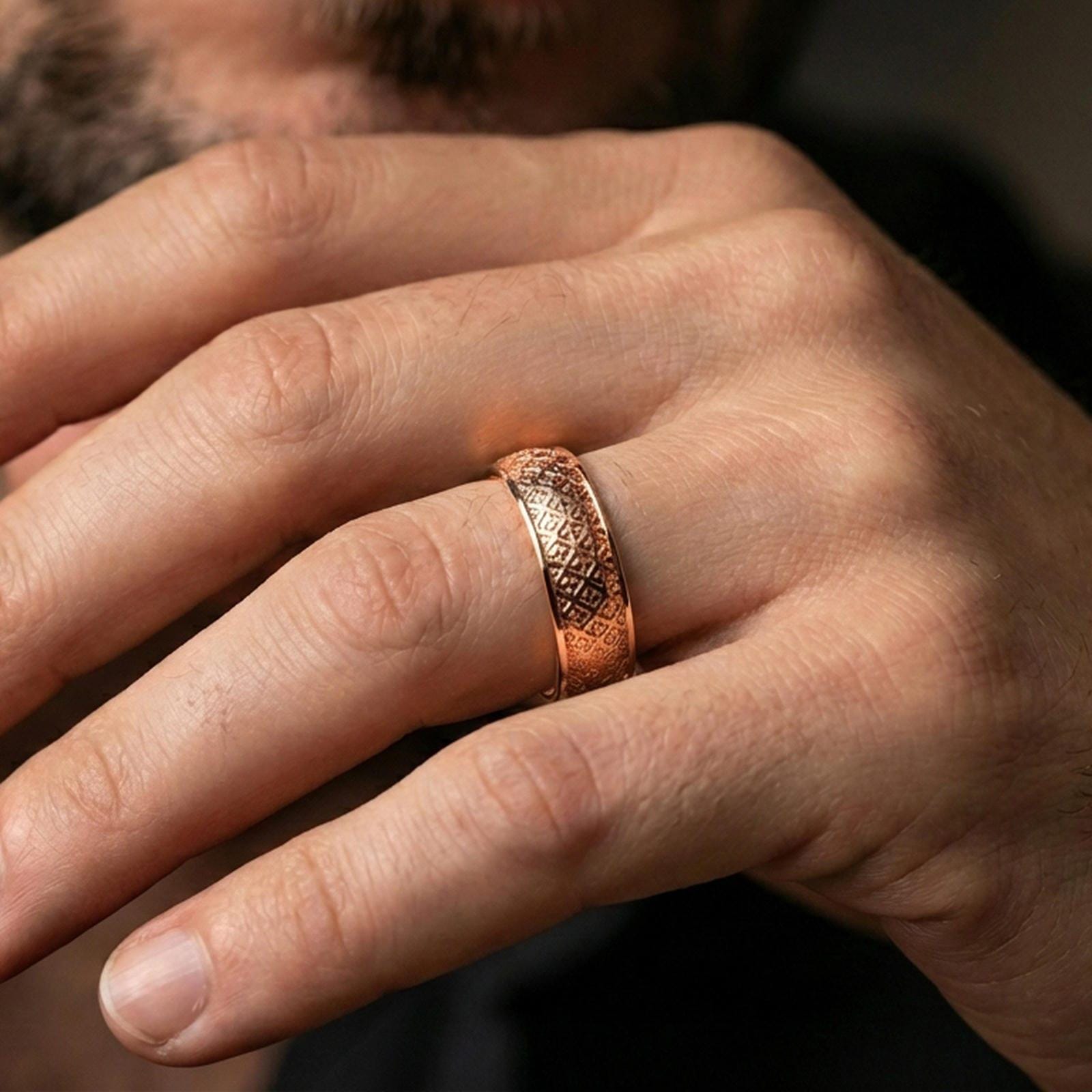 Rose gold plated fleur-de-lis band ring worn on a finger, lifestyle wear photo with elegant rose tone and crisp repeating fleur-de-lis design.