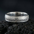 Load image into Gallery viewer, Polished silver fleur-de-lis band ring on volcanic stone, crisp product photo emphasizing the clean relief pattern and bright reflective edges.
