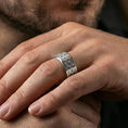 Load image into Gallery viewer, Polished silver geometric floral band ring worn on a finger, lifestyle image capturing bright shine and the structured lattice motif in natural light.
