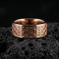 Load image into Gallery viewer, Rose gold plated geometric floral band ring on volcanic stone, refined macro shot featuring soft rose highlights and precise repeating geometric lines.
