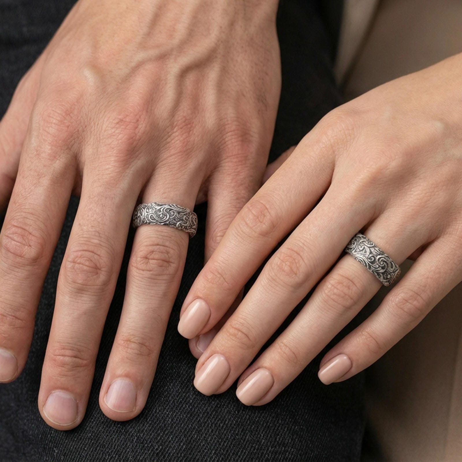 Oxidized sterling silver scrollwork band ring worn on a finger, lifestyle wear photo showing bold contrast and rich vintage texture.