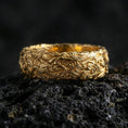 Load image into Gallery viewer, Gold plated scrollwork band ring on volcanic stone, premium macro shot showing warm gold tone across the detailed engraved filigree.
