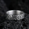 Load image into Gallery viewer, Oxidized sterling silver geometric circle pattern ring on volcanic stone, macro close-up highlighting the carved concentric motifs and dark antique contrast.
