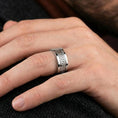 Load image into Gallery viewer, Polished silver Greek key spinner ring worn on a finger, lifestyle photo showcasing sleek modern shine and the continuous meander pattern in motion.
