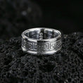 Load image into Gallery viewer, Polished silver Greek key spinner ring on volcanic stone, clean studio macro showing bright shine, sharp geometric pattern, and smooth comfort edges.
