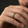 Load image into Gallery viewer, Gold plated wave pattern band ring worn on a finger, lifestyle wear shot emphasizing luxury gold tone, engraved texture, and statement-ready look.
