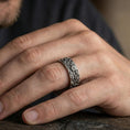 Load image into Gallery viewer, Oxidized sterling silver floral engraved band ring worn on the finger, lifestyle photo focusing on bold antique contrast and detailed botanical relief.
