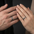Load image into Gallery viewer, Oxidized sterling silver Celtic knot band ring worn on the finger, lifestyle image focusing on bold dark contrast and classic Celtic styling.
