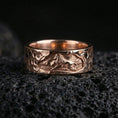 Load image into Gallery viewer, Rose gold plated lion band ring on volcanic stone, refined macro close-up capturing soft rose reflections across the lion relief and hammered surface.
